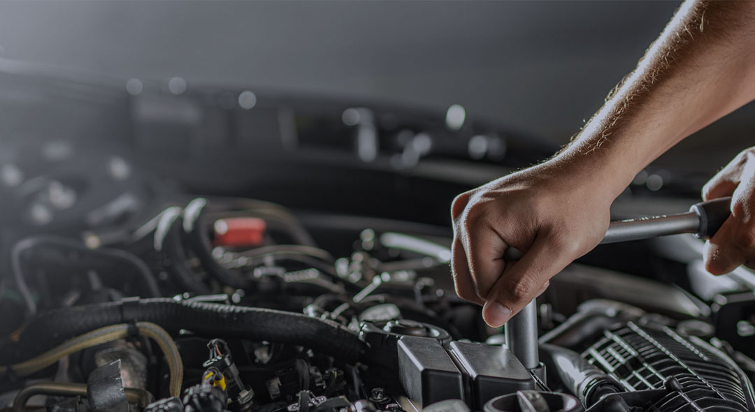 This is an image of a mans hand repairing a car engine.